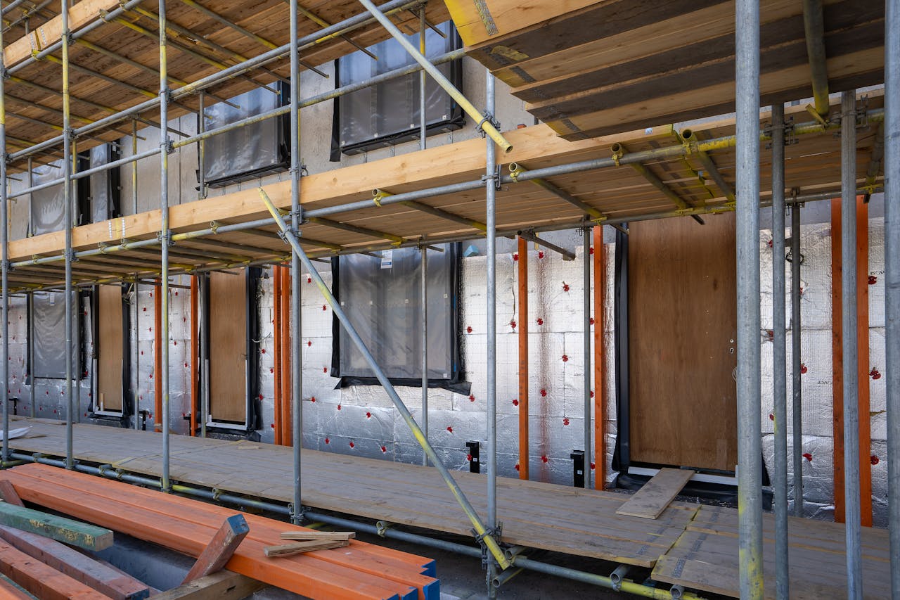 services-02 Scaffolding at a residential building under construction with windows and insulation sheets visible.
